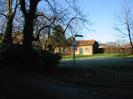 Village green with barn. Trees on the left, and frost on the grass.
Roadsign warning of slow-ramp.