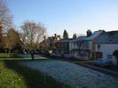 Village Green. Oak and Saw public house in centre of photo, with St Nicolas House to the left. Houses on Rectory Road. Frost on grass and houses.
