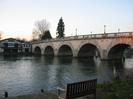 Maidenhead Bridge, with the old Maidenhead Rowing Club building on the left.
Wooden bench seat in the foreground.