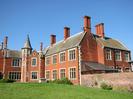 The south wing of Taplow Court.
Two-storey building of red brick with stone details.
Grey slate roof and decorative brick chimneys.
