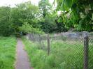 Footpath with low fence on the right.
Trees and elecricity sub-station.