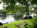 River Thames.
Grassy bank with garden furniture and trees.
Moored boats.