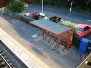 Looking down on the bike shelter on platform 4.
Road and car-park in the background.
Blue equipment cabinet on right.