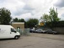Car park with vehicles and small buildings.
Sign advertising MOT testing.