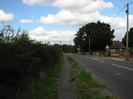 Looking north on Marsh Lane.
Footway and grass verge on left.
Tree and low walls on right.