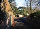 Looking East along Rectory Road, with high red-brick wall on the left.
