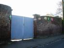 Gates of The Old Rectory, with hubcaps found and decorated by Sheila Horton.
High walls on each side.