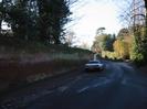 Looking West on Rectory Road. High wall on left, parked car, ice on road.