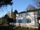 St Nicolas Church and Wellbank Cottage.
White picket fence. White painted house with light blue shutters.
Church steeple shows one face that has been re-sheathed in copper and has not yet turned green.