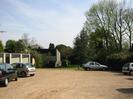 Car park, garages, trees and houses in the distance.