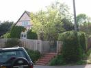 Pink house called Old Cottage.
Wooden fence.
Brick steps to wrought-iron gate.
Parked car.
Telephone pole.
Entrance to footpath visible on the right.