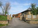 The entrance to Hill Farm.
Sandy-coloured brick walls with wooden fence panels.
Red-brick barn with red tile roof.
New house of sandy brick with dark slate roof.