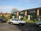 Rear of Church Cottages and front of Buffins houses.
Brick end-walls, tile-hung fronts at first-floor level, white front doors, large windows.
Parked cars.