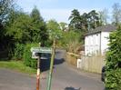 The top of High Street.
Public footpath sign (pointing the wrong way).
Trees.
White house with dark slate roof.