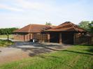 Long low house and garage, built from red-brown brick with red clay tiles.
Grass area and granite-chip driveway.
This building was originally the winery for Taplow Vineyard.