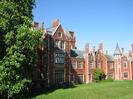 The south face of Taplow Court.
Very large house of red brick with stone details.
Grey slate roofs with red brick chimneys.