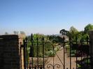 View through wrought-iron gate into formal gardens.