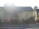 Looking across Berry Hill, straight into the sun.
Cream-painted building with dark slate roof.
