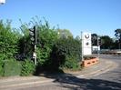 East side of Berry Hill.
Roadside cabinet and traffic light on left, in front of hedge.
Low brick wall and BMW/Mini dealership sign.
Cars on forecourt on right.