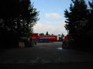 Entrance to storage yard.
Dark trees on both sides.
Trailers in yard.