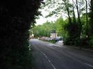 Looking north on Mill Lane.
Dark trees on left.
Paper mill entrance in the distance.
Car-park on the right.