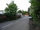 Looking north on Mill Lane.
High wall on left with boathouses and house in the distance.
Trees on the right.