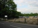 Large trees on left.
Gates and car-parks on right.
Trees in the distance.