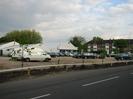 Car dealership with cars and vans parked around it.
Flats in the distance on the other side of the A4 Bath Road.