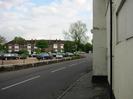 Looking south on Mill Lane.
Cars on dealer's forcourt on left, with block of flats behind.
Disused hotel building on right.