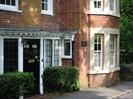 Mulberry House.
Red brick building with white windows and black door.
Some windows have stone surrounds.
Low hedges each side of door.