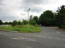 Road junction with Boundary Road in the foreground and Station Road on the right.
Grass area with street light.
Dark trees on right.