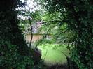 Bungalow seen through trees.