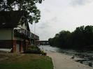 River Thames just below Maidenhead Bridge.
Maidenhead Rowing Club building on left.
Concrete quay and pontoons, with geese.
Boy fishing from far pontoon.
Brunel's famous railway bridge in the distance.
Bank of large trees on far bank of river.