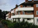 River Court flats.
Three-storey buildings with white concrete balconies.
Red brick on upper floors.
Gardens in front.