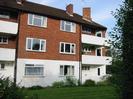 River Court flats 7-12.
White walls on lower floor, red brick on upper two floors.
White balconies.
Grass and shrubs in front.