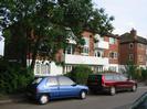 River Court flats 1-6.
Trees and parked cars on road.