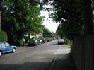 Looking south along River Road.
Parked cars on both sides.
River Court flats visible through trees on left.
Entrance to rowing club on right.