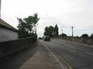Looking west across Maidenhead Bridge.
Part of derelict house on left.
Lamp-posts on bridge parapet.
Trees in the distance.