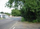 Looking east along the Bath Road.
Windrush Volkswagen dealership on left.
Grass verge and trees on right.
Telephone box in distance.