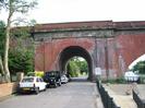 Looking south on River Road, through the side-arch of Brunel's famous brick railway bridge across the Thames.
Iron railings and terrace on the right, with river beyond.