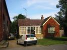 Bungalow beside railway bridge.
Parked cars.