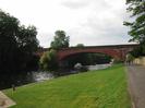 River Thames with Brunel's famous brick railway bridge in the distance.
Grassy bank with road on right.