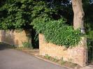 Sandy brick walls and gateways.
Trees behind wall.