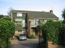 Green Tiles: Brick house with green roof tiles.
Some walls clad in green wood, others painted green.
Gravel drive with ivy-covered gateposts and iron gates.