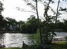 River Thames.
Large house behind trees on far bank.
Trees and moored boats on near bank.