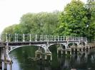 Footbridge to Guards Club Island.
Bridge is supported on wooden piles, and has an elegant structure of white painted ironwork.
Trees in the background are on the island.