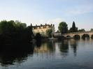 River Thames upstream from Guards Club Island.
Bank of dark trees on left.
Thames Riviera Hotel / Blue River Cafe in centre: four storey cream-painted building with red tile roof.
Maidenhead Bridge on right: sandy-coloured stone arches.