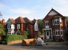 Two houses: both two storeys high, built of red brick with red tile roofs.
Driveway between houses.