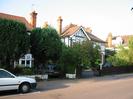 Houses with black and white paint and red tile roofs.
Trees in front gardens.