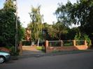 Road, pavement, low brick wall with ironwork inset.
Sign on wall: "BYWAYS".
Gate leading to brick pavior drive with goalpost.
Silver birch tree in lawn, with house beyond.
Trees and telephone pole alongside road.